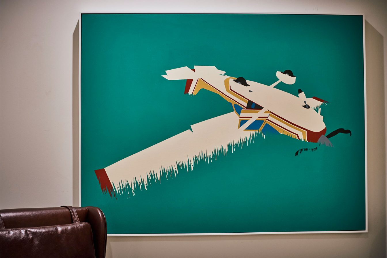 Artwork of a plane in the grass, framed at our Detroit boutique hotel