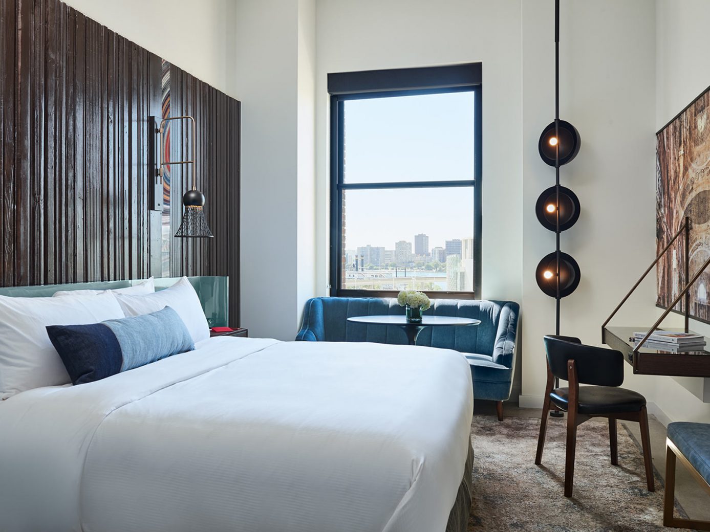 Bed, sofa, and desk in one of our downtown Detroit hotel's rooms