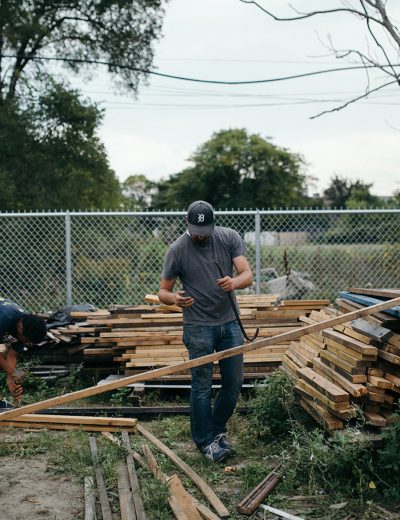 Men sorting through large stacks of wood near our Detroit, MI lodging