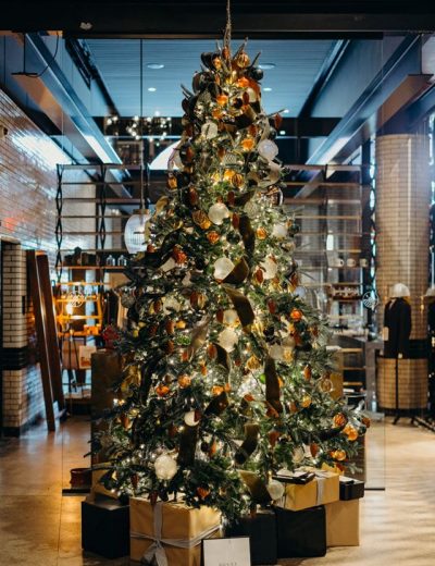 Large lit up Christmas Tree with gold wrapped presents at our boutique downtown hotel in Detroit