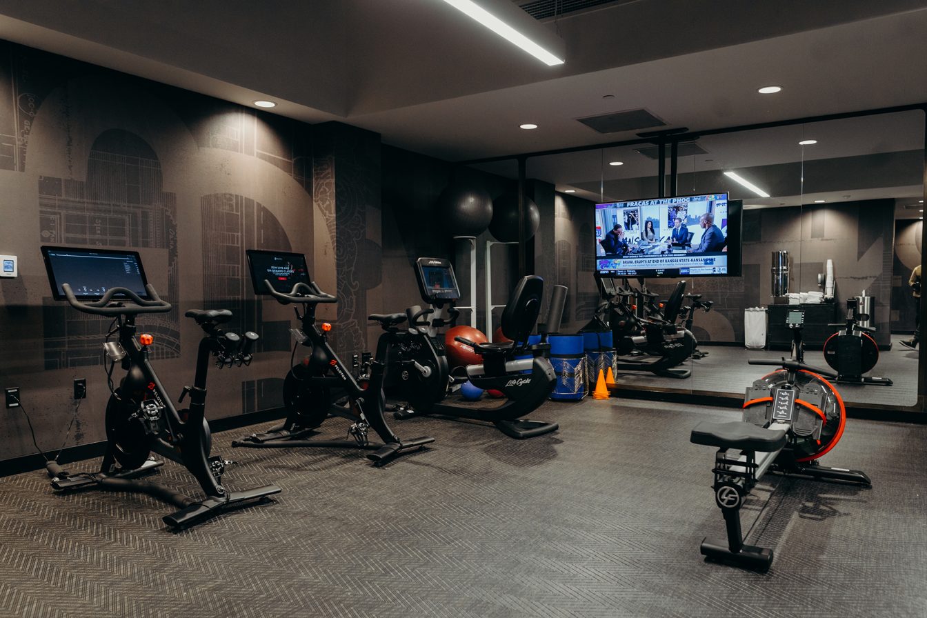 Recumbent and upright exercise bikes, rower, and tv, at our Detroit hotel's fitness center.
