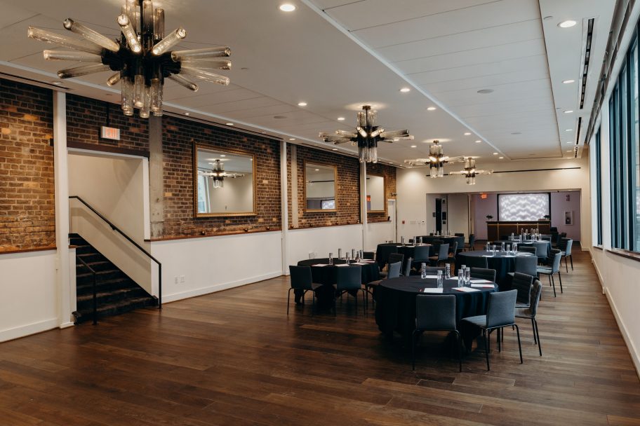 Downtown Detroit event space with round tables and exposed brick