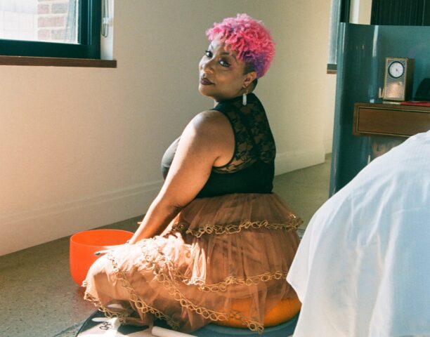 Pink-haired woman on the floor of our Detroit hotel, gazing at the camera