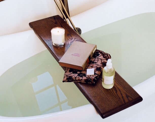 Book, candle, and body wash on a bath tray at our hotel in Detroit, MI