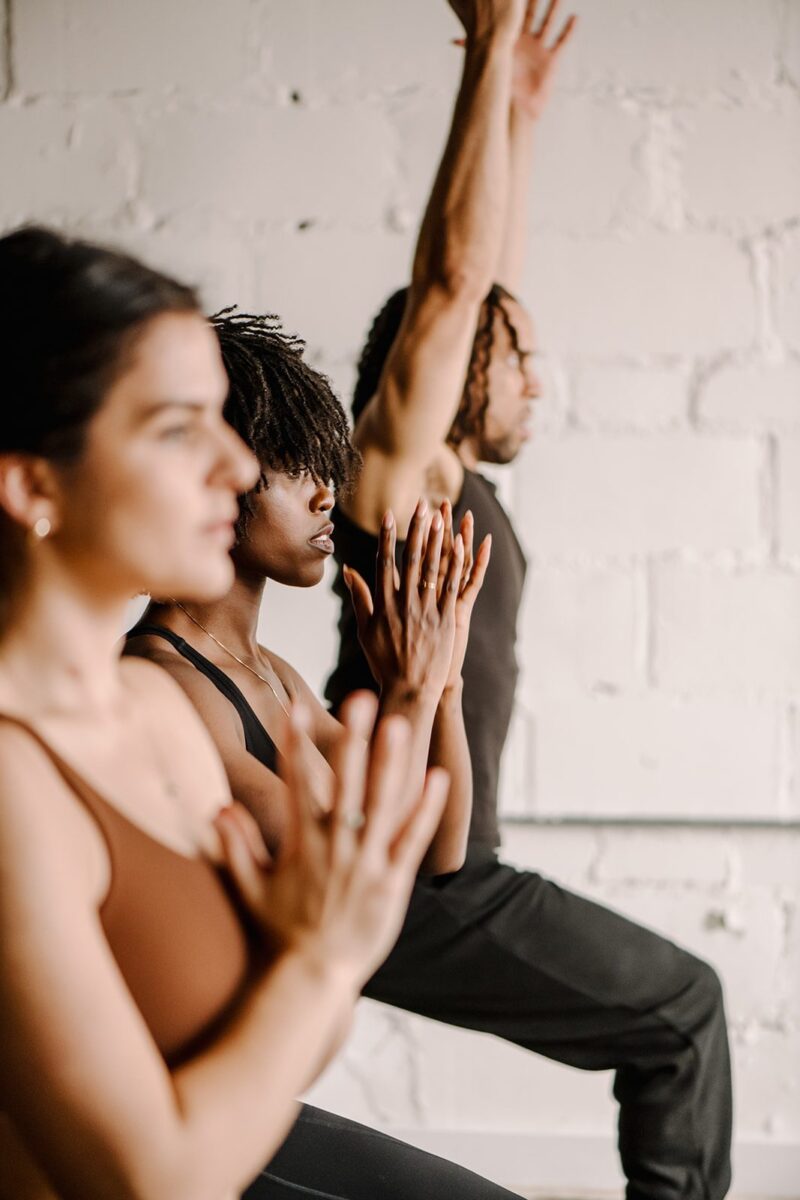 Three people lined up in various yoga poses at our Detroit boutique hotel