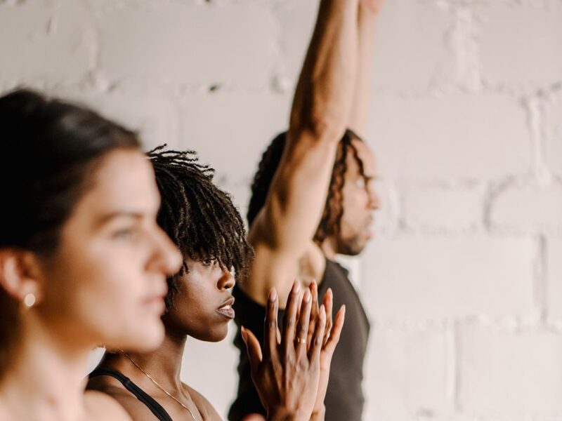 Three people lined up in various yoga poses at our Detroit boutique hotel