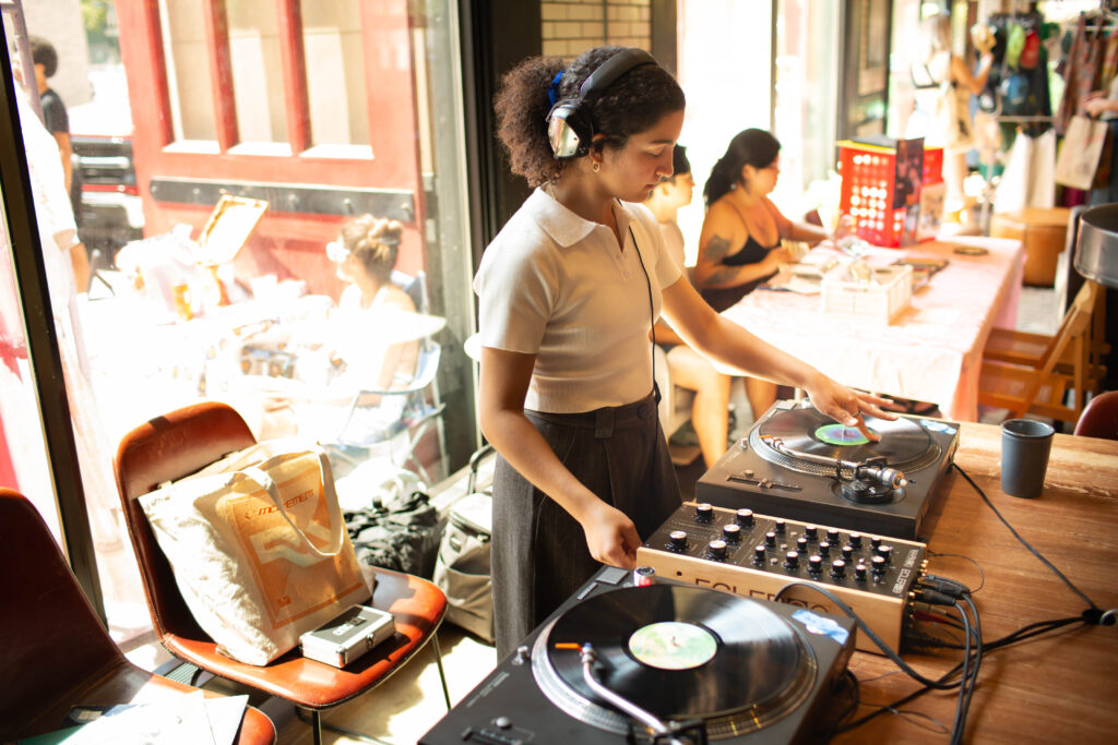 a woman standing behind DJ decks