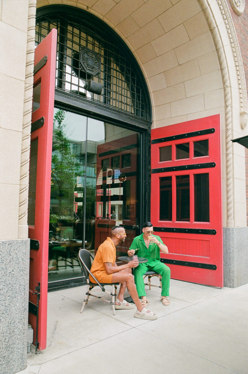 People outside of Detroit Foundation Hotel having a conversation with drinks in their hands.