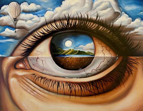 Close-up of a painted human eye with a landscape reflected in the iris, showing clouds and a hot-air balloon in the sky.