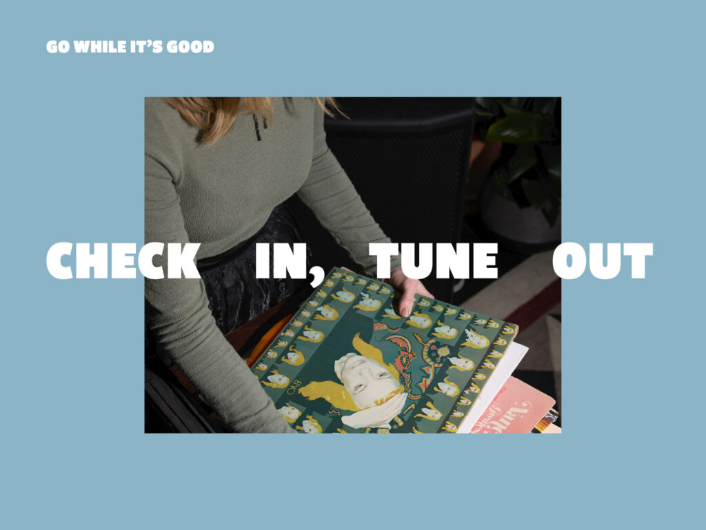 Blue page hero with bold white text 'Go while it’s good' and 'Check in, tune out' over a person holding a colorful magazine.