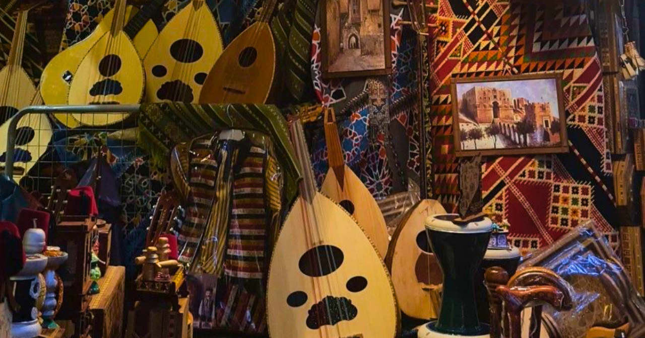 Shop window filled with colorful stringed instruments (ouds) and woven textiles, creating a vibrant market scene.