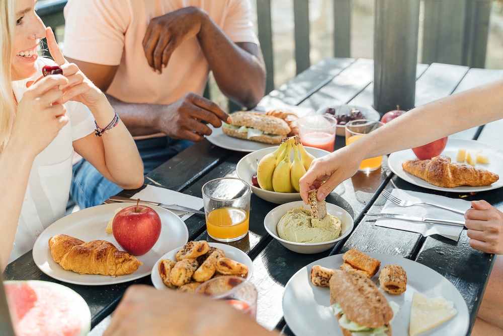 people sat outside together enjoying food and drink
